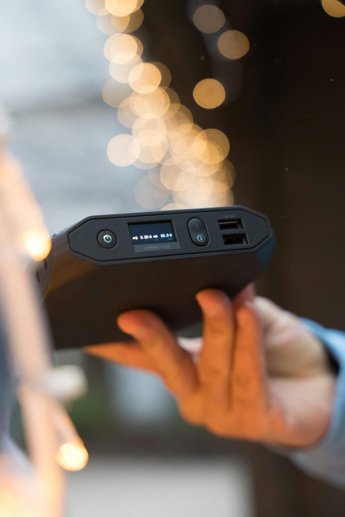 A person holding a power bank in front of a christmas tree